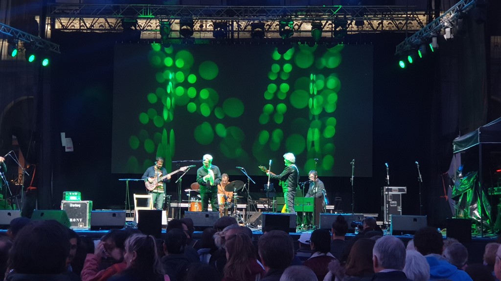 Concierto de Eliseo Parra en el Festival Folk de San Pedro Regalado en Valladolid. Aparecen cinco miembros del grupo tocando: Bajo, Batería, Pandero, Guitarra y Teclado